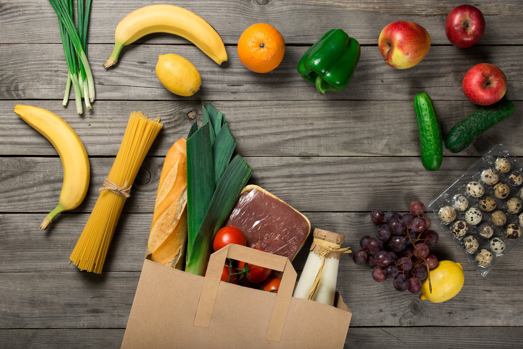 Groceries in paper bag on wooden table